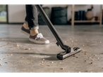 A vacuum cleaner cleans a garage floor.