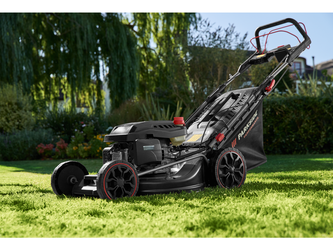 PARKSIDE PERFORMANCE petrol lawnmower in a green, sunny garden