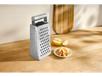 Ralador de cozinha Silvercrest® com maçãs raladas numa mesa de madeira