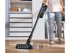 Person cleaning a wooden floor with a cordless wet and dry vacuum cleaner.