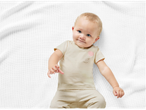 Baby in beige bodysuit and pants.