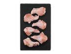 Šešios žalios vištienos blauzdelės ant juodos skalūno lentos.