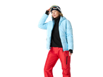 Woman in light blue ski jacket, black fleece, red ski pants, and ski goggles.