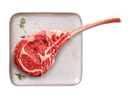 Rohes Tomahawk-Steak auf einer Platte mit Kräutern und Gewürzen.
