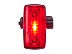 Red bicycle taillight with a bright central LED, isolated on a white background.