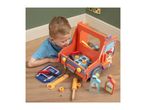 A child playing with a wooden toy truck, tools, and car fluids on a wooden floor.