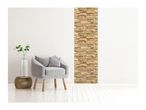 Modern living room with a gray armchair, a plant in a vase, and a stone accent wall.