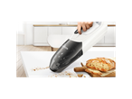 A Bosch cordless vacuum cleaner cleaning bread crumbs from a white kitchen counter.