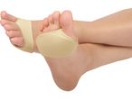 A pair of feet wearing beige metatarsal pads, isolated on a white background.