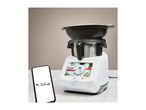 A white smart kitchen appliance with a screen displaying recipes, next to a smartphone showing 'works with Ok Google'.