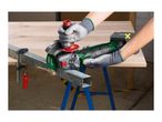 Cordless angle grinder cutting a metal bar on a workbench