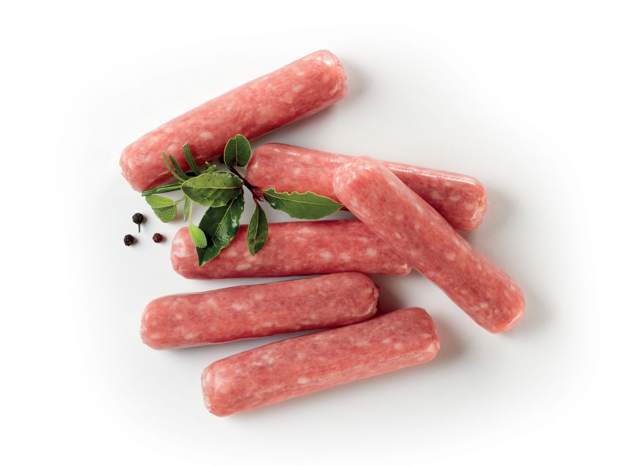 Salsicce crude disposte su sfondo bianco con erbe aromatiche e pepe.