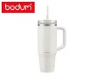 White travel mug with a handle and straw, featuring a minimalist design.