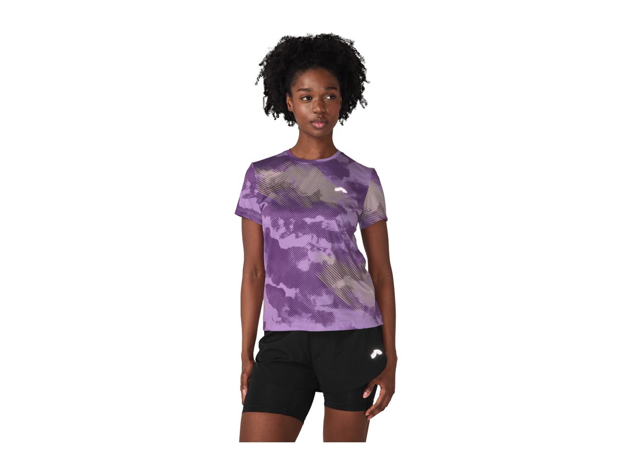 Woman in a purple patterned short-sleeved top and black shorts.