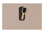 A wooden paddle brush with black bristles resting on a black zippered pouch.