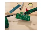 Soldering iron and circuit board on a wooden surface, with RAM and solder wire.