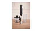 Black hand blender set with a chopper and measuring beaker on a wooden countertop