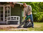 Um homem usa um soprador de folhas Parkside para recolher folhas em seu jardim.
