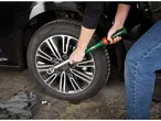 Una persona usa una chiave dinamometrica per stringere i dadi di una ruota d'auto.