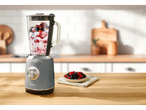 Um liquidificador SilverCrest cinza claro com um smoothie de frutas vermelhas em uma bancada de madeira.