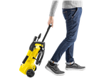 Person pulling a yellow Kärcher 1600W Pressure Washer with wheels.