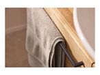 Grey towel hanging on a black towel bar next to a wooden vanity and white sink.