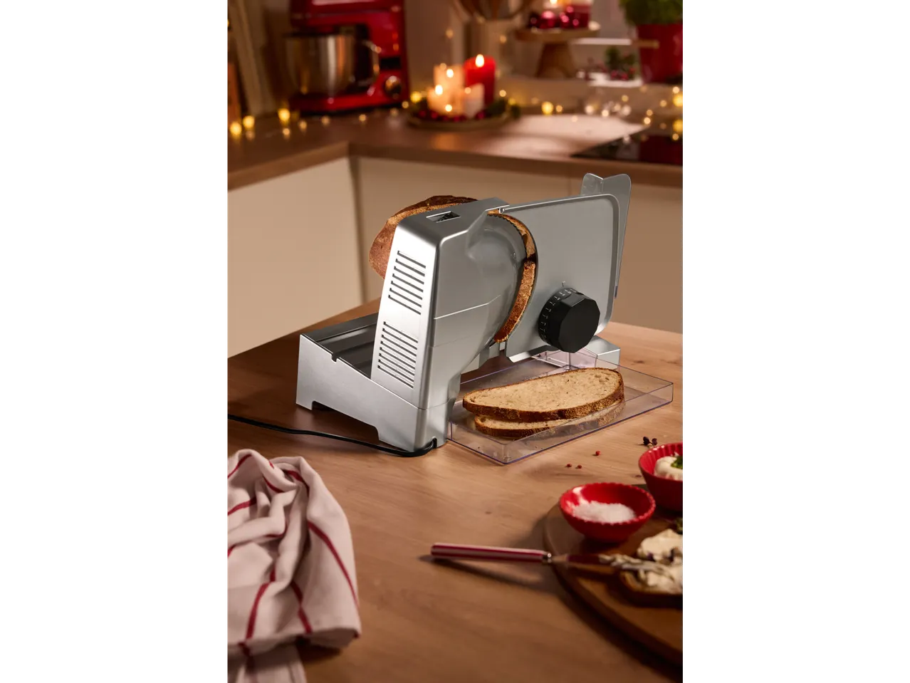 Electric slicer with freshly sliced bread in a festive kitchen.