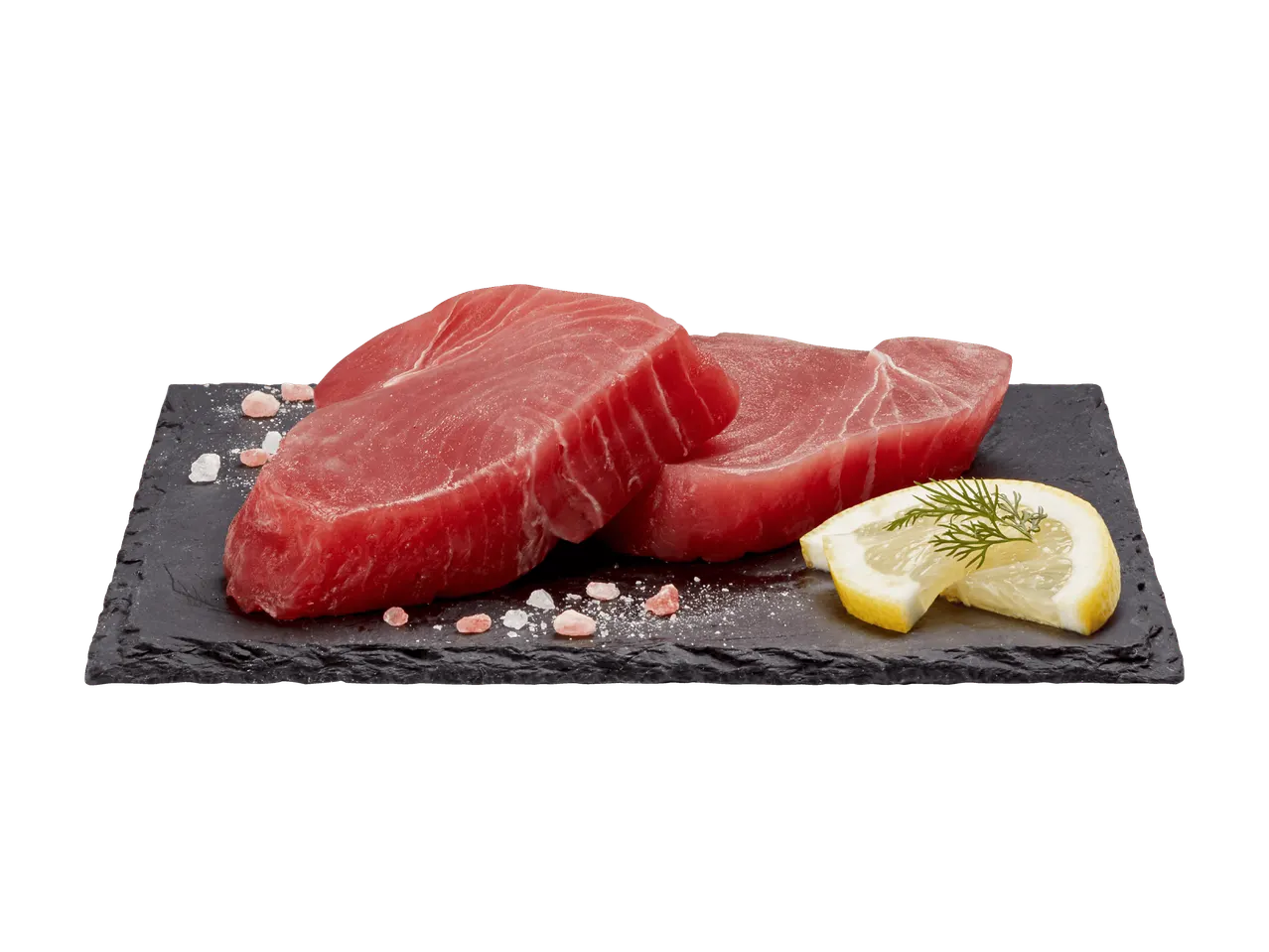 Frische Thunfischsteaks auf einem Schieferbrett mit rosa Salz und Zitrone.