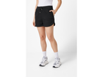 Femeie purtând pantaloni scurți negri și adidași albi.