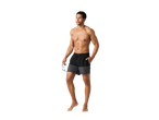 Un bărbat musculos cu pantaloni scurți de baie negri și gri ține o pereche de ochelari de soare.