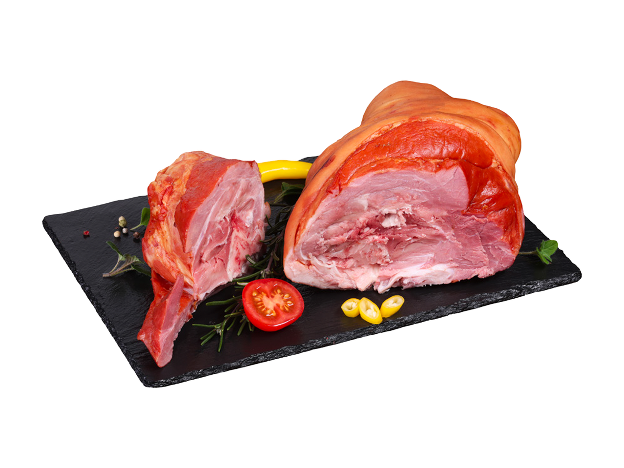 Dimljena svinjska kolenica i plećka sa začinima i povrćem na crnoj ploči.