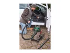 Man vacuuming car interior with a wet and dry vacuum cleaner