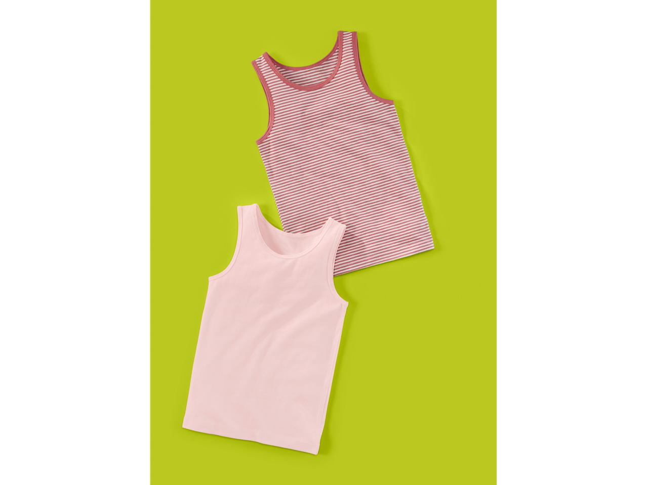 Two children's tank tops, one plain pink and one pink and white striped, on a green background.