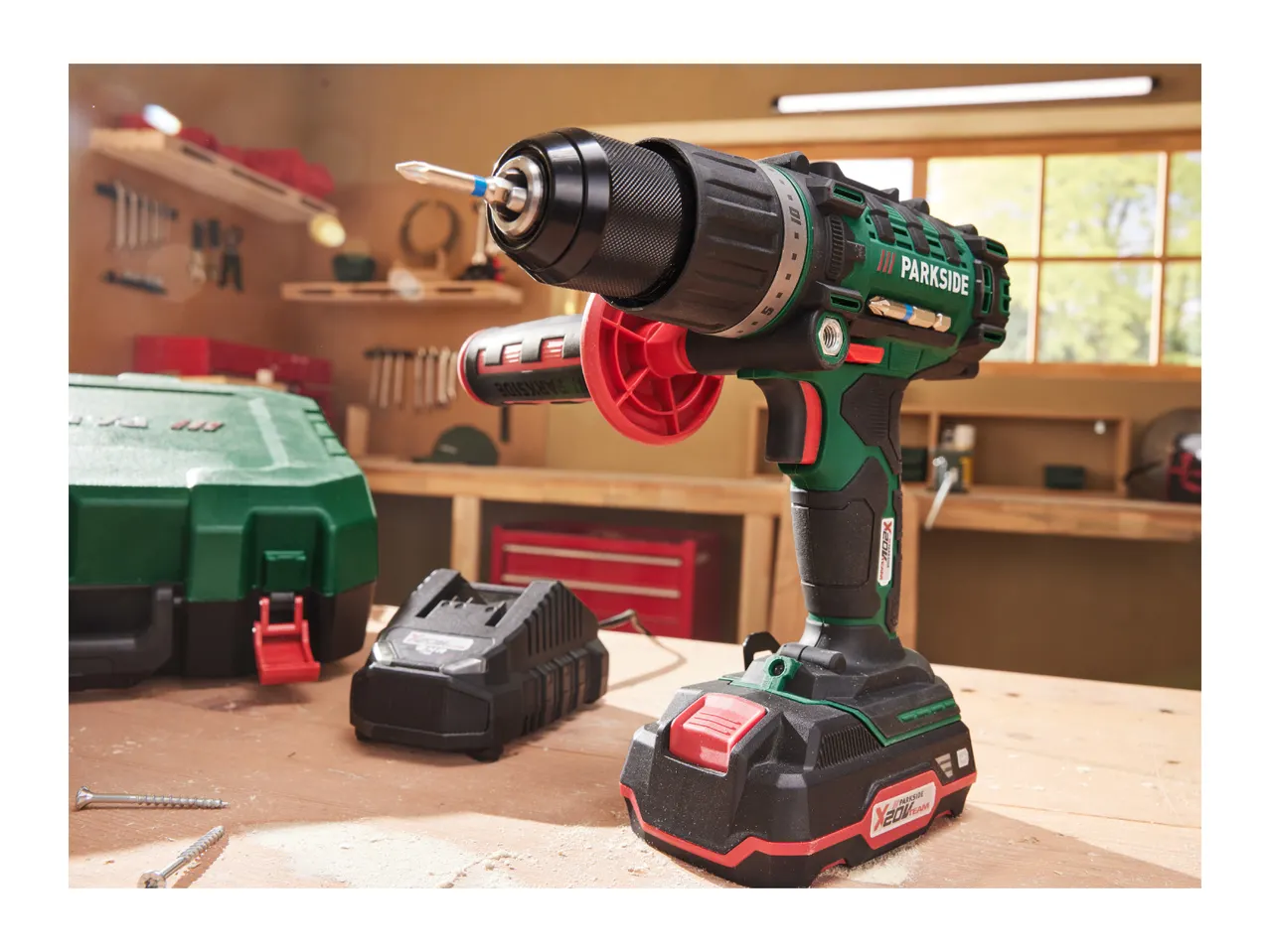 A Parkside 20V cordless drill and battery charger sit on a workbench in a workshop.
