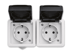 Zwei weiße Steckdosen mit schwarzen Klappdeckeln
