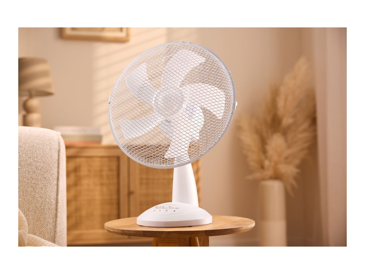 White table fan on a wooden side table in a cozy living room.