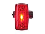 Red bicycle taillight with a bright yellow light in the center, on a white background.