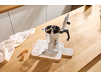 Espressor SILVERCREST pe un tocător de marmură cu biscotti și un pahar pe un blat de lemn.