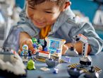 A child plays with LEGO City Space toys, including astronauts and a lunar rover.