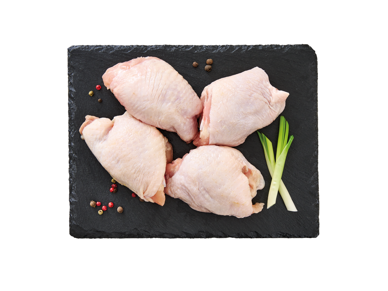 Toored broilerikintsud pipraterade ja rohelise sibulaga mustal kiltkiviplaadil.