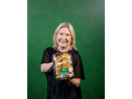A woman holding a package of garlic toasties against a green background.