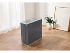 A gray mattress wrapped in clear plastic sits on a light wood floor.