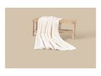 A soft, cream-colored faux fur blanket draped over a rustic wooden bench.