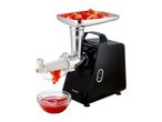 Tomato press with tomato pieces in the tray and tomato puree in a bowl.