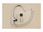 A chrome kitchen faucet and its installation parts, including hoses and washers, laid out on a beige surface.