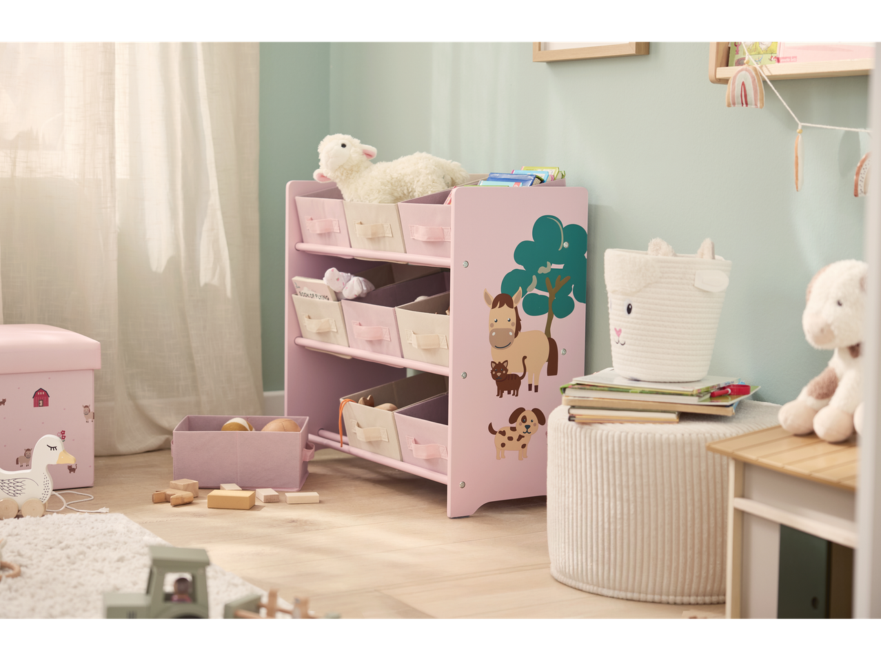 Estante rosa LIVARNO com gavetas e motivos de animais em quarto infantil.