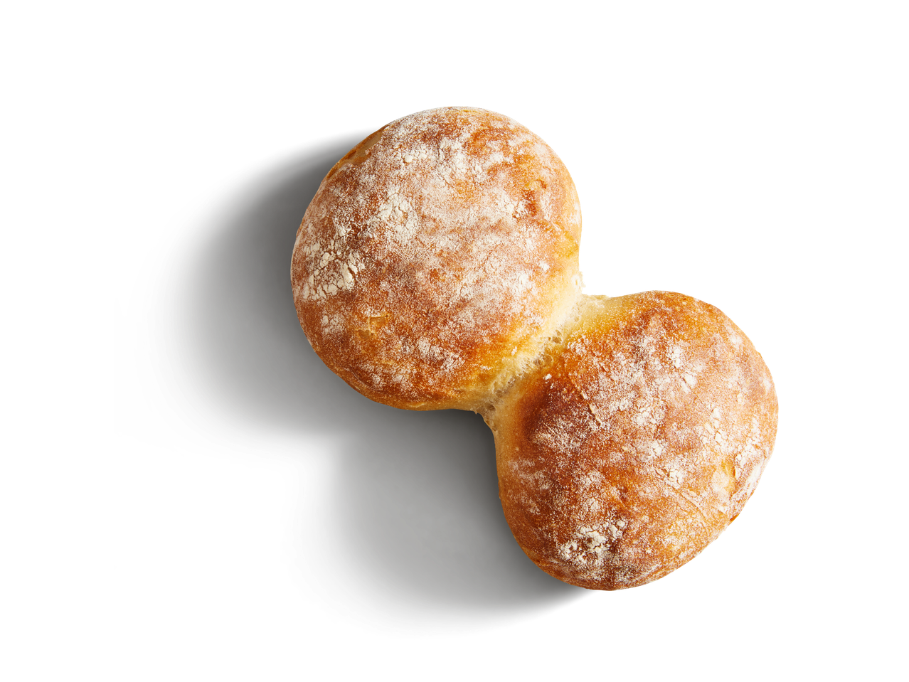 SP Dinkel Bürli, ein goldbraunes, bemehltes Brötchen auf dunklem Hintergrund.