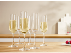 Flutes de champanhe SILVERCREST® com bebida dourada numa mesa de madeira, com frutas ao fundo.