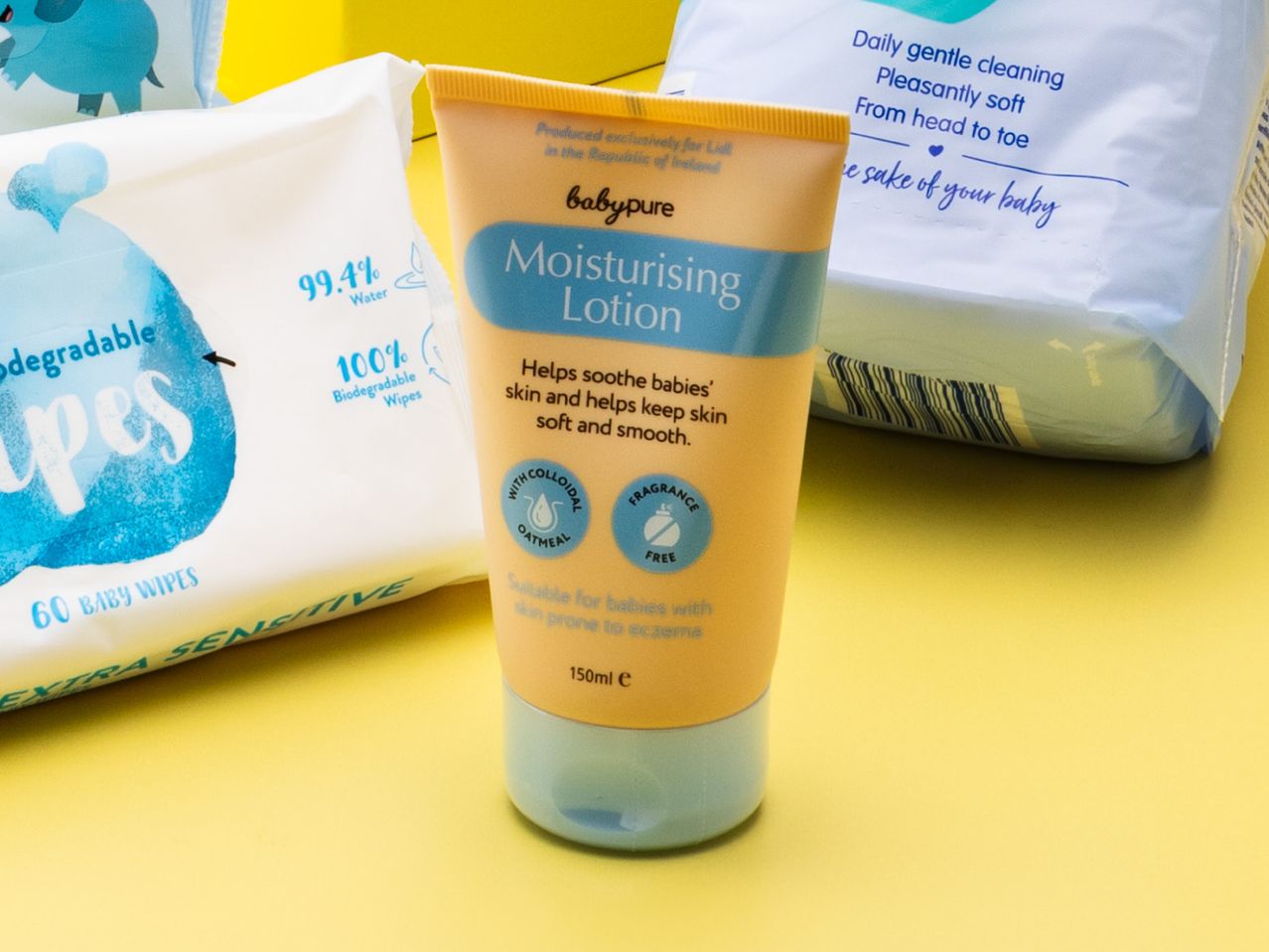 BabyPure moisturizing lotion and baby wipes on a yellow background.