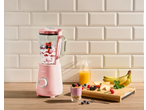 Liquidificador rosa SILVERCREST com frutas, iogurte e sumo de laranja numa bancada de madeira.
